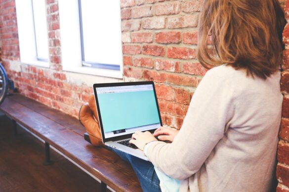 Mulher sentada em banco usando internet no computador